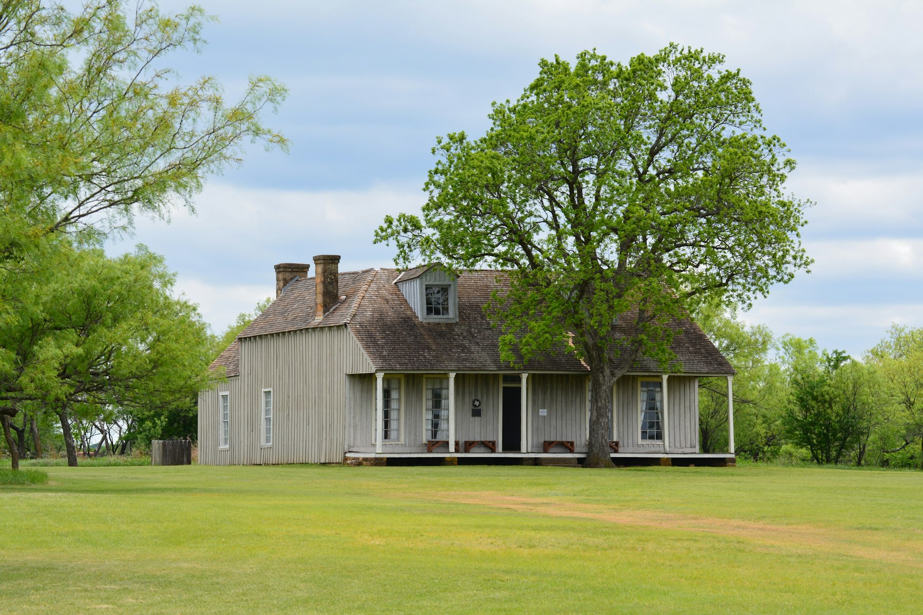 Una casa de madera en Texas bajo un roble